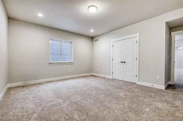 an empty room with windows and closet