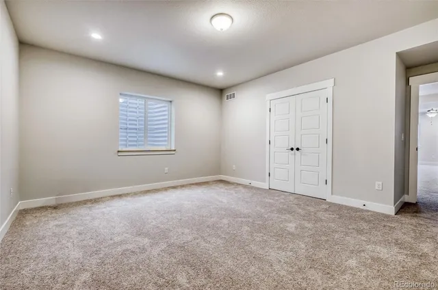 an empty room with windows and closet