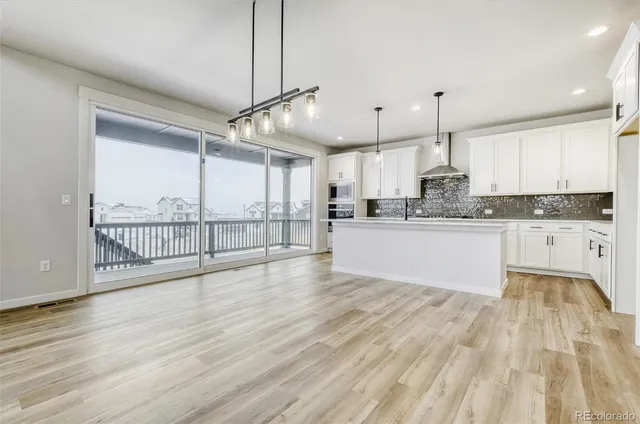 a large kitchen with stainless steel appliances kitchen island granite countertop a large cabinets a sink and wooden floor