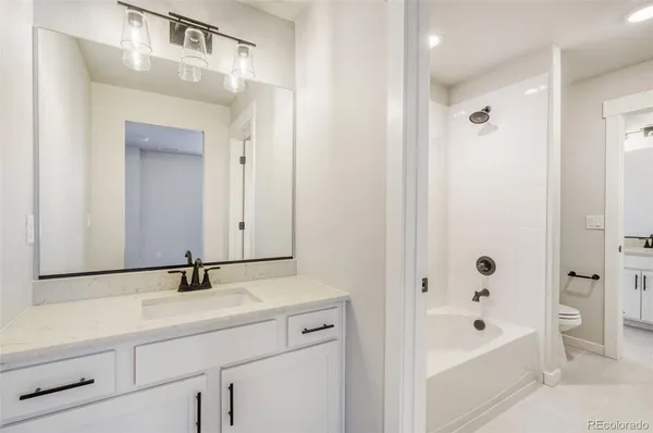 a bathroom with a bathtub a sink a mirror and a shower