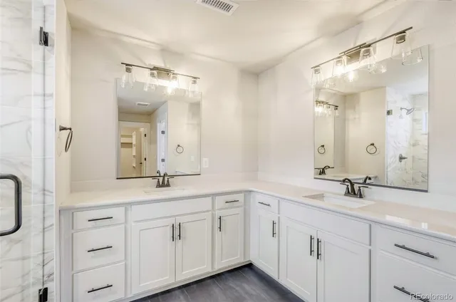 a bathroom with a double vanity sink mirror double and shower