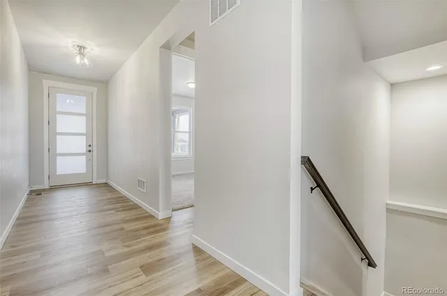 wooden floor in an empty room with wooden floor and stairs