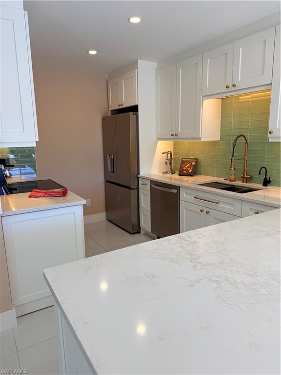 1575 Curlew Avenue, Unit 1 Naples, FL 34102 - Photo 24 of 35 Kitchen with decorative backsplash, white cabinetry, new appliances, light tile floors, and recessed lighting and beautiful gold pot filler