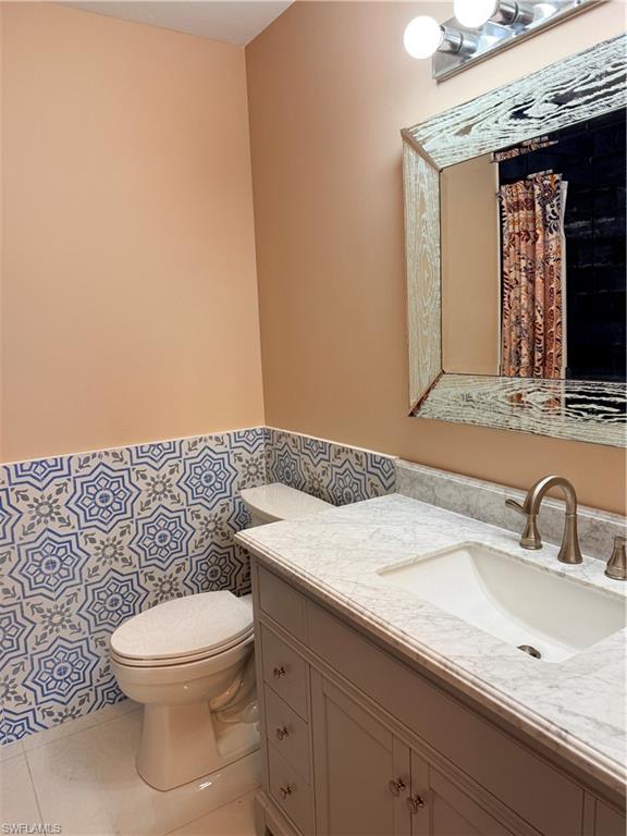 1575 Curlew Avenue, Unit 1 Naples, FL 34102 - Photo 31 of 35 Primary bathroom featuring light tile patterned flooring, vanity, with Italian tile walls
