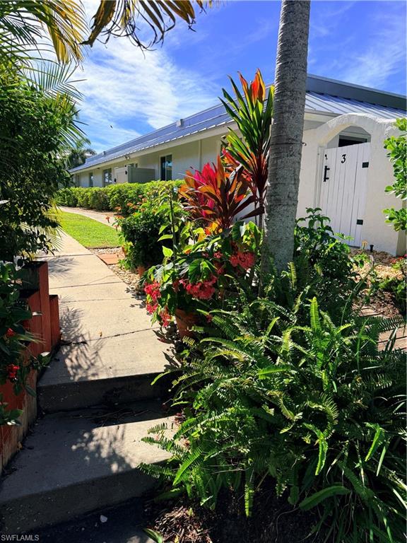 1575 Curlew Avenue, Unit 1 Naples, FL 34102 - Photo 7 of 35 Entry filled with flowers and fauna leading to the dock