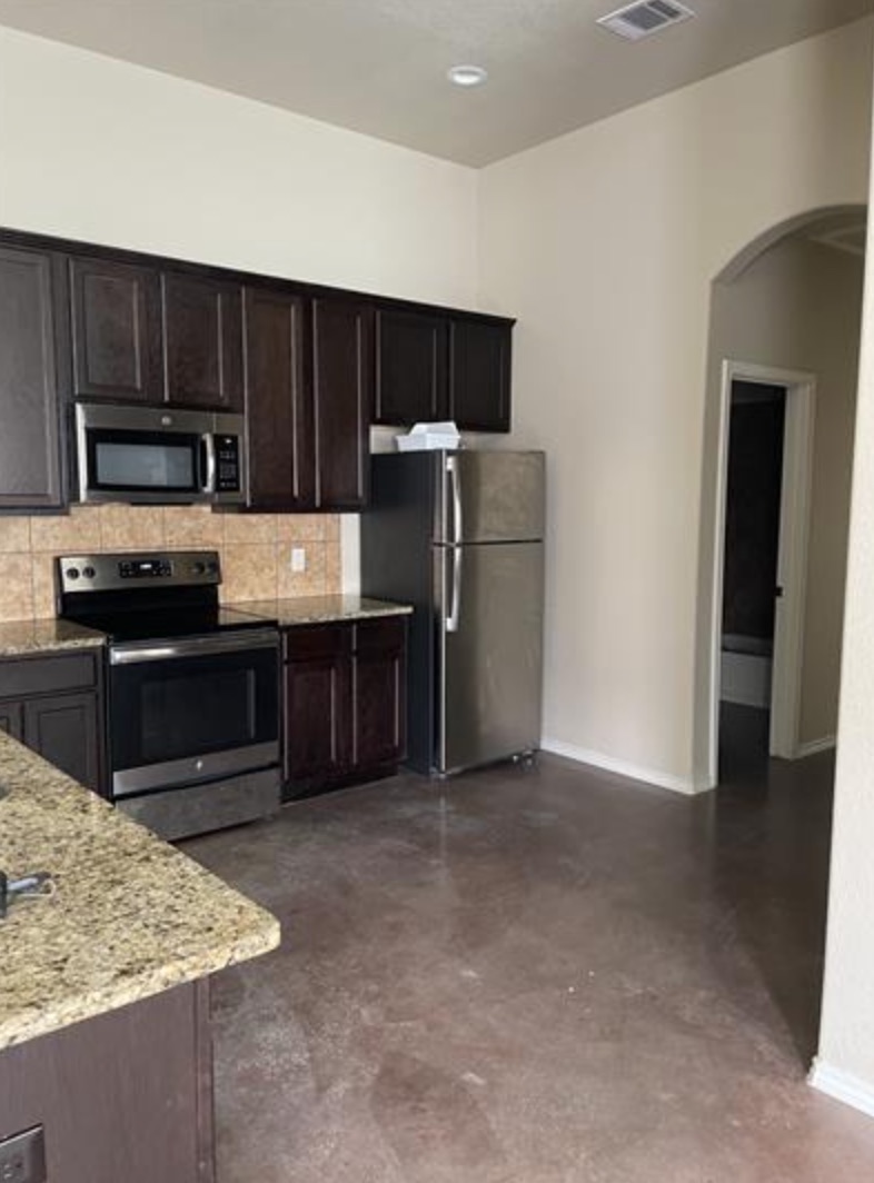 601 Jack Rabbit Lane, Unit B Buda, TX 78610 - Photo 4 of 10 a kitchen with a refrigerator and a sink