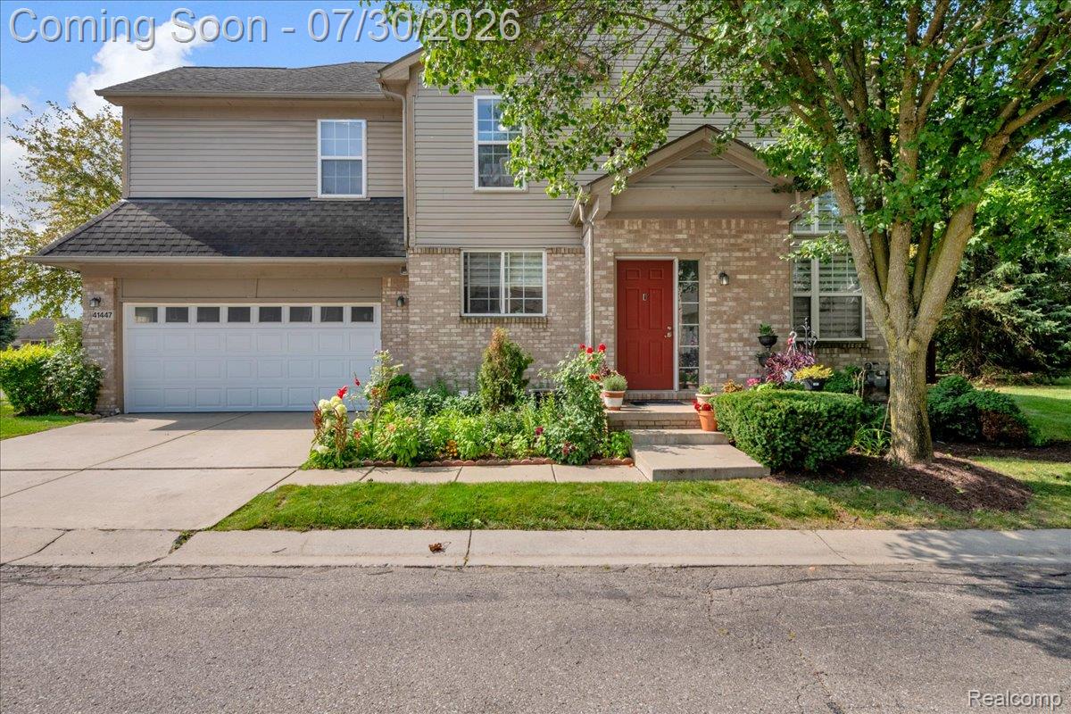 Two-story residence featuring a brick and siding exterior, a two-car garage, and a concrete driveway