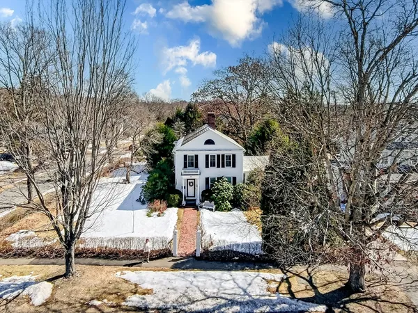 a white house that has a tree in front of it