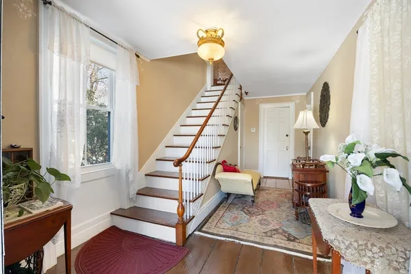 a view of entryway and hall with wooden floor