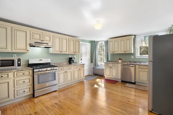 a kitchen with granite countertop white cabinets and white appliances