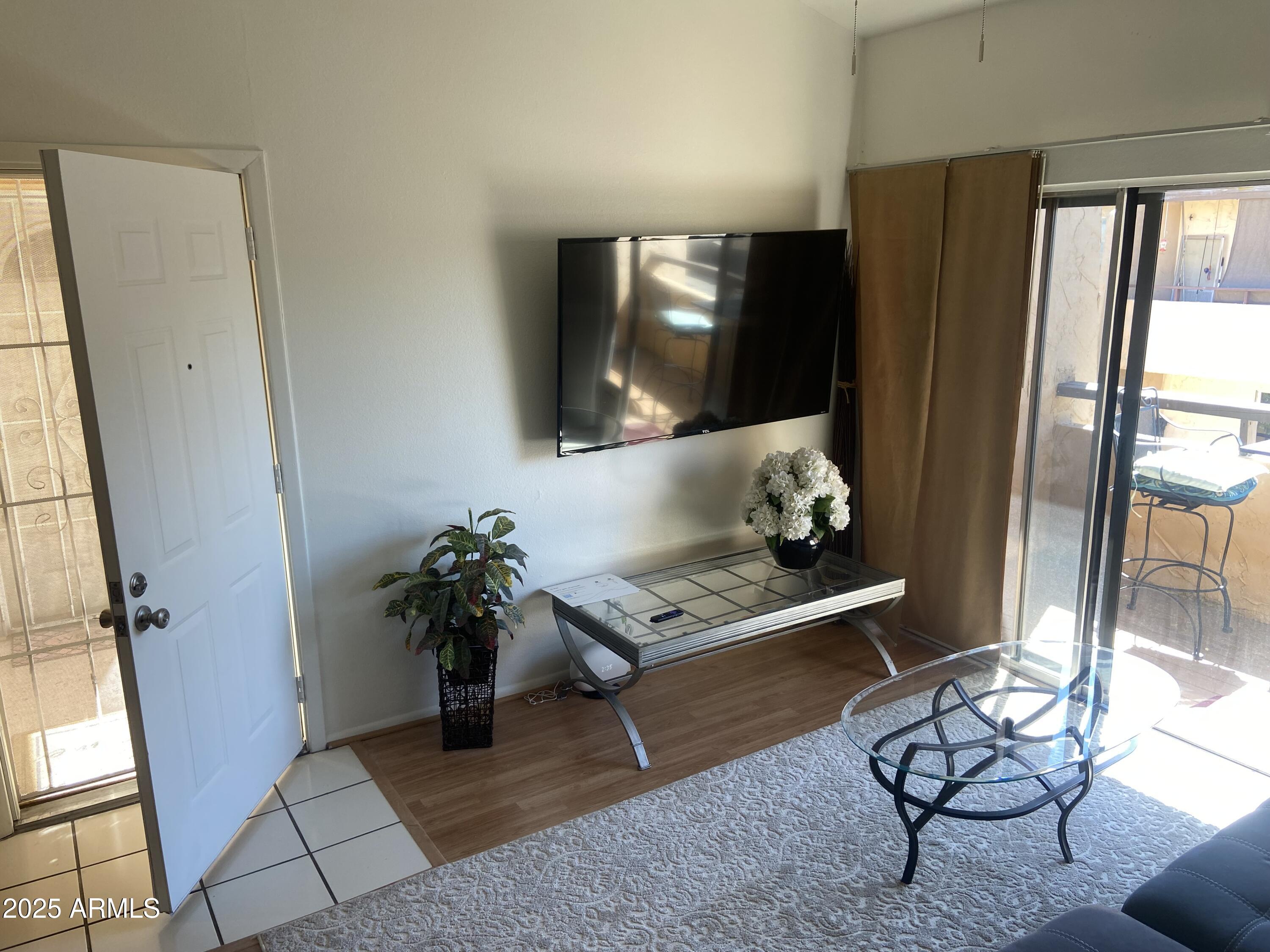 8055 East Thomas Road, Unit A303 Scottsdale, AZ 85251 - Photo 15 of 25 a living room with furniture and a flat screen tv