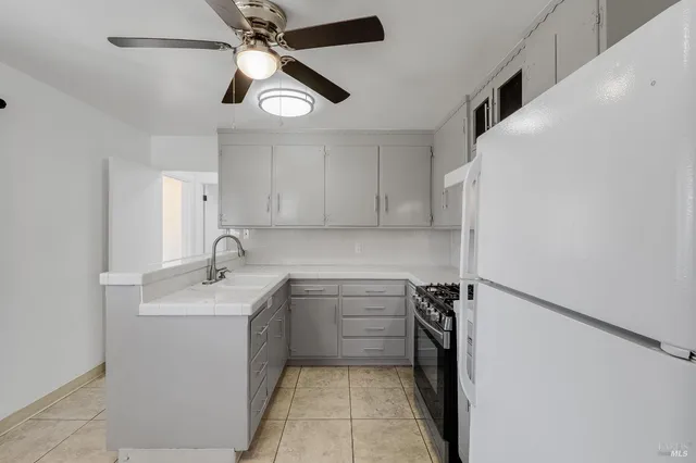 a kitchen with a sink dishwasher and white cabinets