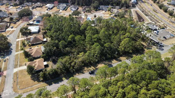 an aerial view of residential house with parking and yard