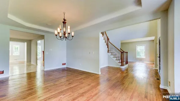 a view of a livingroom with wooden floor and a chandelier