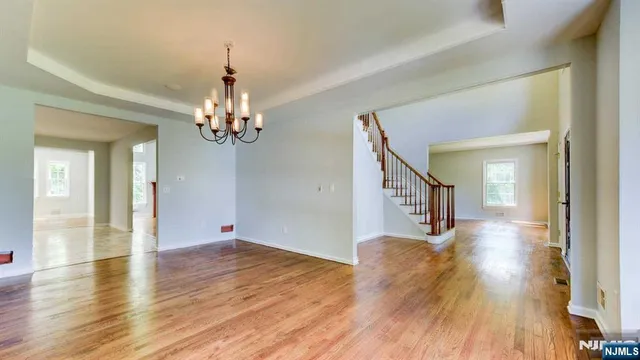 a view of a livingroom with wooden floor and a chandelier