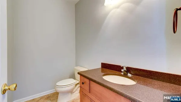 a bathroom with a granite countertop toilet and a sink