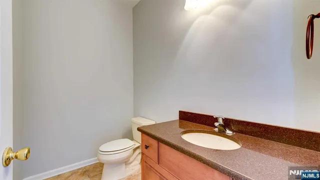 a bathroom with a granite countertop toilet and a sink