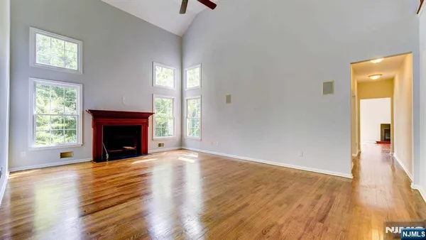 a view of empty room with wooden floor and fireplace