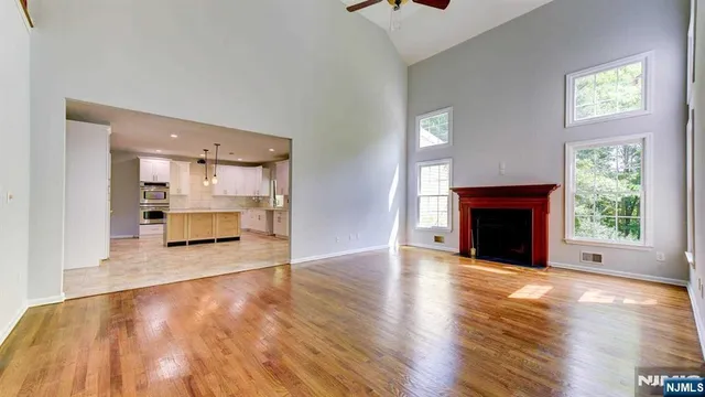 a view of empty room with wooden floor and fireplace