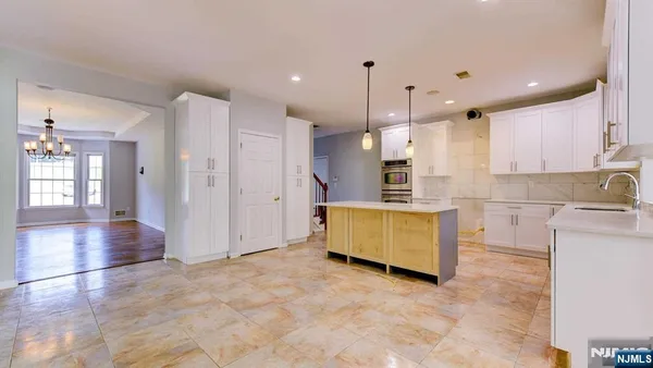 a view of a kitchen with kitchen island a sink stainless steel appliances and cabinets