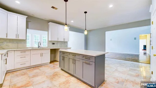 a kitchen with stainless steel appliances granite countertop a sink a stove and a refrigerator