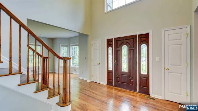 a view of front door with hallway and wooden floor