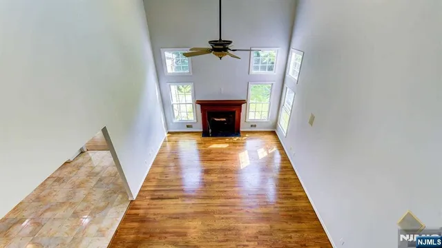 a view of a livingroom with wooden floor staircase and a fireplace