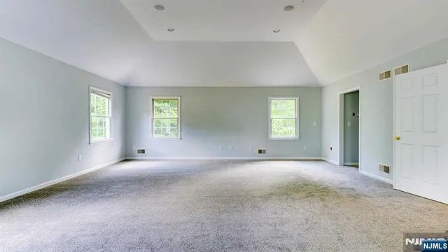 an empty room with windows and closet