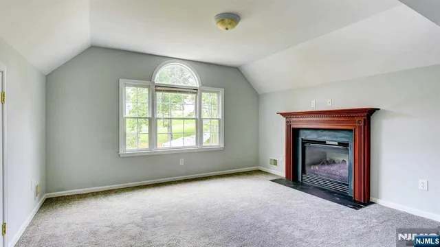 an empty room with a fireplace and windows