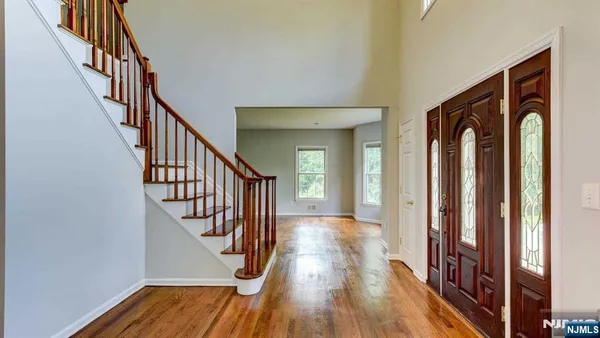a view of an entryway with wooden floor and stairs