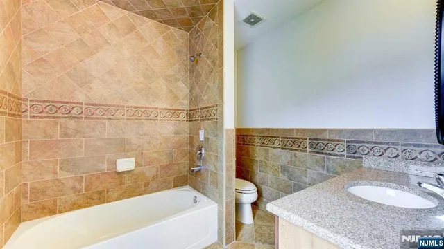 a bathroom with a granite countertop bathtub shower sink and vanity