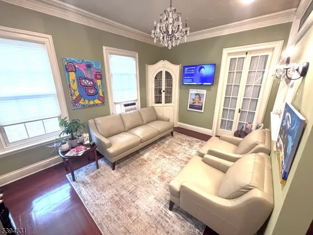 a living room with furniture a fireplace and a chandelier