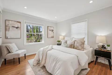 a spacious bedroom with a bed and wooden floor