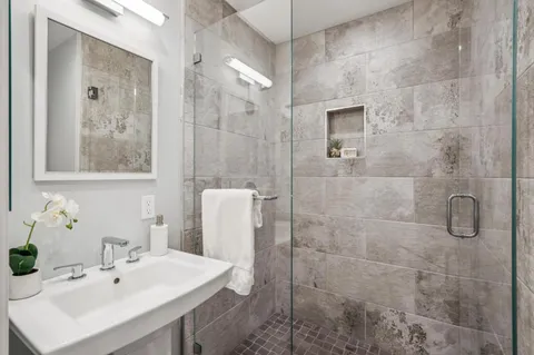 a bathroom with a sink shower and mirror