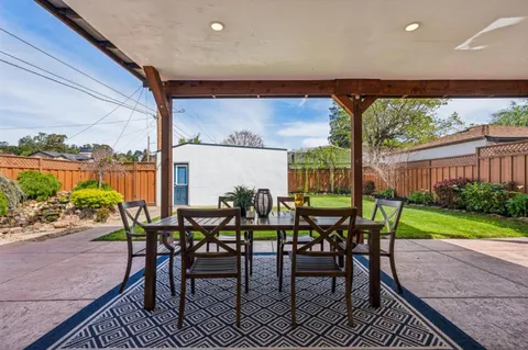 a view of an outdoor dining space with furniture and garden