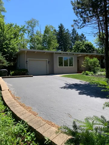 a front view of a house with a yard and trees