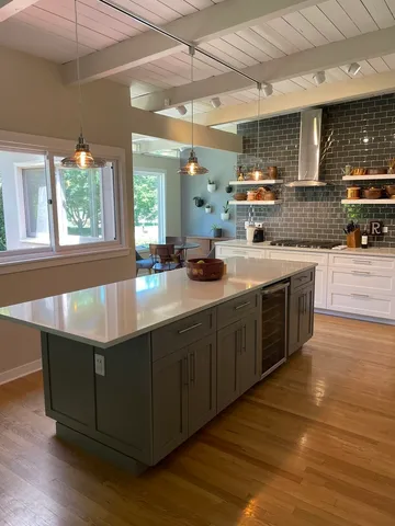 a kitchen with stainless steel appliances granite countertop a sink a stove top oven a counter space and cabinets