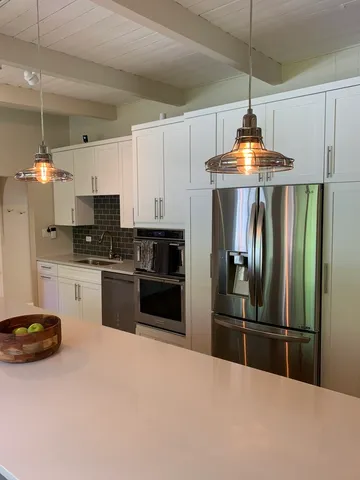 a kitchen with kitchen island stainless steel appliances a stove a refrigerator and a sink