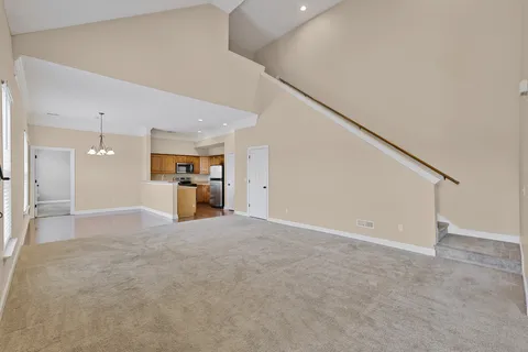 a view of empty room with a kitchen