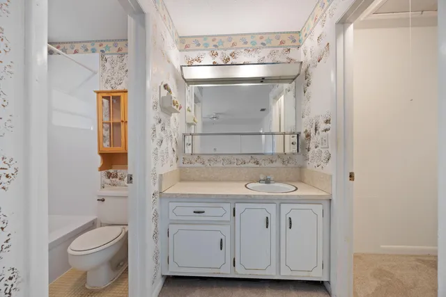 a bathroom with a granite countertop sink toilet and shower