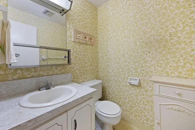a bathroom with a granite countertop toilet and sink
