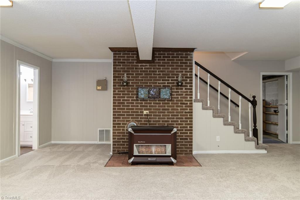 8220 Styers Ferry Road Clemmons, NC 27012 - Photo 22 of 30 Basement playroom with gas heater (also serviced by HVAC system)