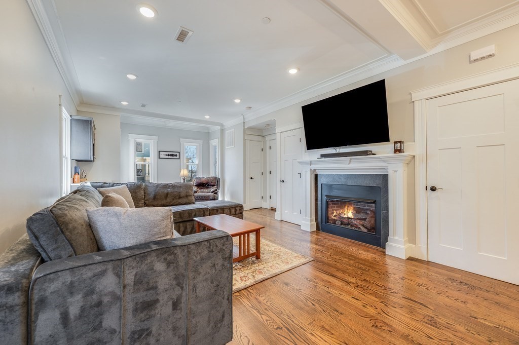 11 Preston Road, Unit 2 Somerville, MA 02143 - Photo 3 of 30 a living room with furniture a flat screen tv and a fireplace