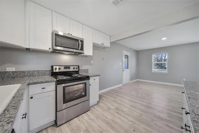 a kitchen with stainless steel appliances granite countertop a stove and a microwave