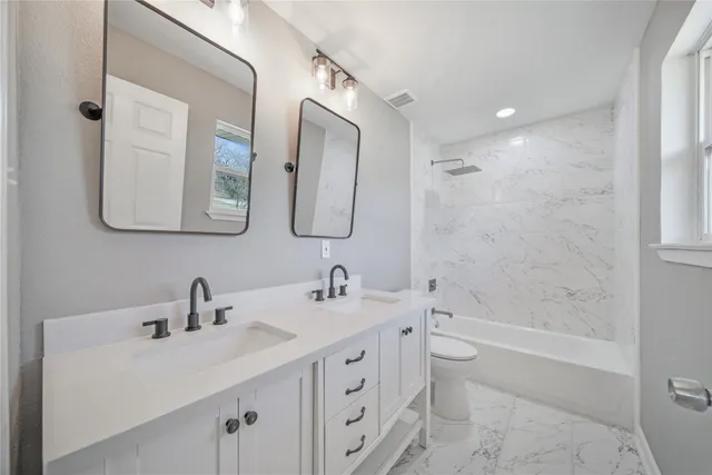 a bathroom with a double vanity sink mirror double and bathtub