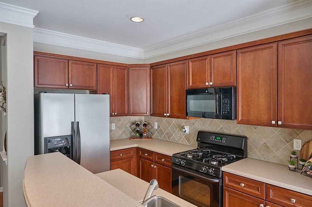14183 Yacht Terrace Alpharetta, GA 30004 - Photo 11 of 30 a kitchen with stainless steel appliances granite countertop a refrigerator stove and sink