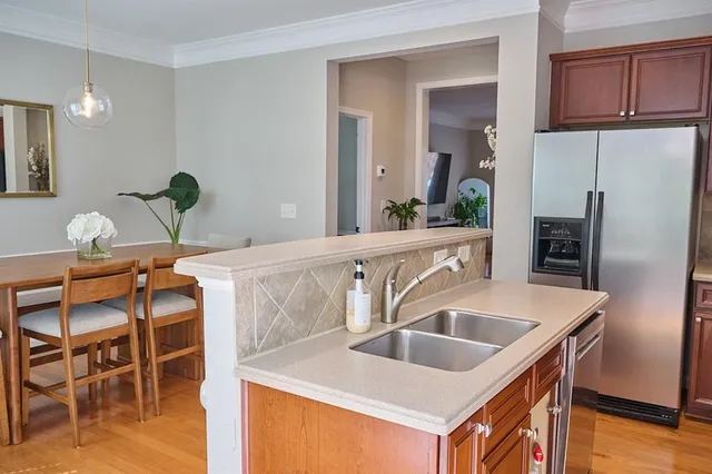 a kitchen with stainless steel appliances wooden floor dining table and chairs