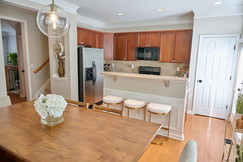 14183 Yacht Terrace Alpharetta, GA 30004 - Photo 13 of 30 a kitchen with stainless steel appliances wooden floor dining table and chairs