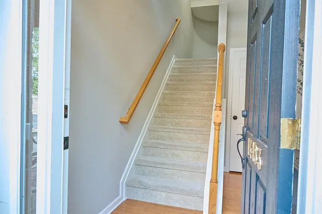 a view of staircase with white walls and white door