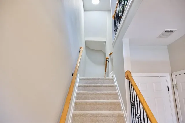 a view of staircase with lots of frames on wall and stairs